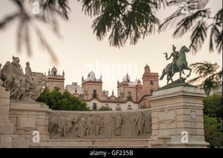 Vista parziale di Plaza de España, nel quartiere storico di Cádiz, al tramonto. Nella parte centrale dell'immagine, le cime di Foto Stock