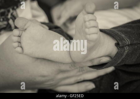 Close up del neonato Boy piedi nella madre le mani Foto Stock