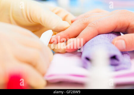 Giovane donna sta diventando manicure in un salone di bellezza Foto Stock