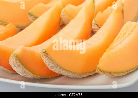 Il melone Cantalupo, fettine di arancia sul piatto Foto Stock