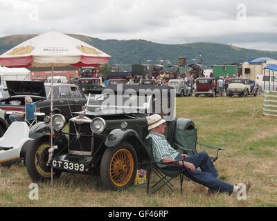 Vicino a Malvern, Regno Unito. 29 Luglio, 2016. Un vintage auto appassionato di prendere un po' di riposo dalla sua Riley dopo girovagare per il Welland Fiera di vapore vicino a Malvern, Regno Unito. Vapore e macchinari vecchi appassionati provenienti da tutto il paese frequentano questo evento annuale che è ora nella sua cinquantaduesima anno. Credito: Richard Sheppard/Alamy Live News Foto Stock