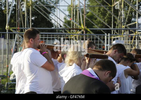 Cracovia in Polonia. 29 Luglio, 2016. La croce è condotta attraverso la folla di pellegrini verso l altare. Centinaia o migliaia di pellegrini venuti a Blonia Park a Cracovia per seguire le stazioni della Via crucis. Le stazioni sono state adattate dal Vescovo Ausiliare di Cracovia Grzegorz Ryś dalle tradizionali stazioni, per correlare più giovani. Credito: Michael Debets/Alamy Live News Foto Stock