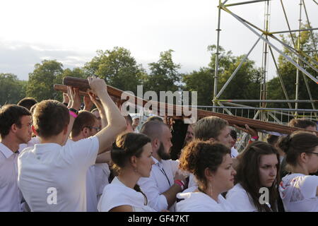 Cracovia in Polonia. 29 Luglio, 2016. La croce è condotta attraverso la folla di pellegrini verso l altare. Centinaia o migliaia di pellegrini venuti a Blonia Park a Cracovia per seguire le stazioni della Via crucis. Le stazioni sono state adattate dal Vescovo Ausiliare di Cracovia Grzegorz Ryś dalle tradizionali stazioni, per correlare più giovani. Credito: Michael Debets/Alamy Live News Foto Stock