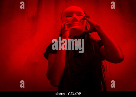 Misteriosa donna in abito nero indossando maschera bianca,Scary sfondo per Halloween Foto Stock