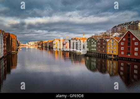 Vecchie case su colonne di legno a Trondheim, Norvegia. All'uscita del fiordo, vi è un moderno ponte. Foto Stock