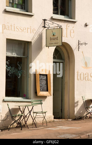 Regno Unito, Inghilterra, Devon, Honiton, High Street, pavimentazione tavoli fuori Toast Cafe Foto Stock