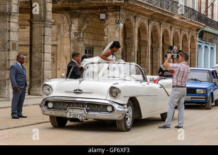 Novelli sposi celebrare il loro matrimonio con un tour di La Habana in una sommità aperta classic car, Paseo de Marti (Prado), Old Havana, Cuba Foto Stock