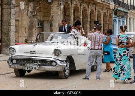 Novelli sposi celebrare il loro matrimonio con un tour di La Habana in una sommità aperta classic car, Paseo de Marti (Prado), Old Havana, Cuba Foto Stock