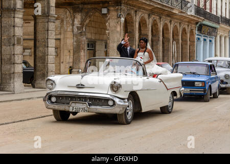 Novelli sposi celebrare il loro matrimonio con un tour di La Habana in una sommità aperta classic car, Paseo de Marti (Prado), Old Havana, Cuba Foto Stock