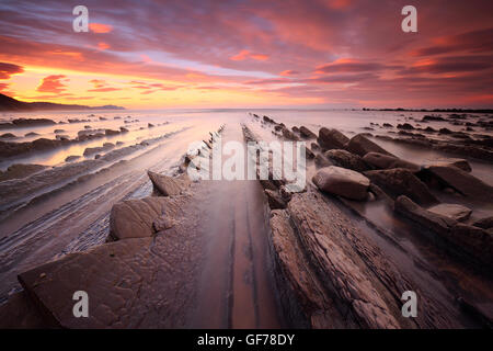 Incredibile tramonto sul flysch formazione geologica in spiaggia Sakoneta (Zumaia, Paese Basco) Foto Stock