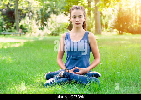 Bella ragazza adolescente medita in un giardino Foto Stock