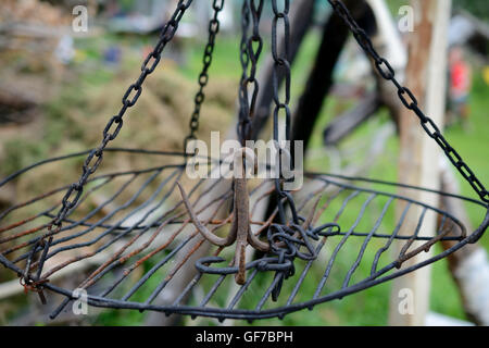 Di ferro arrugginito gancio triplo su griglia appesi a catene. Profondità di campo. Foto Stock