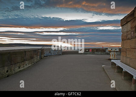 Luce della Sera sul molo di Whitby con regolazione del sole oltre il punto Kettleness. Whitby, nello Yorkshire, Inghilterra, Regno Unito, GB Foto Stock