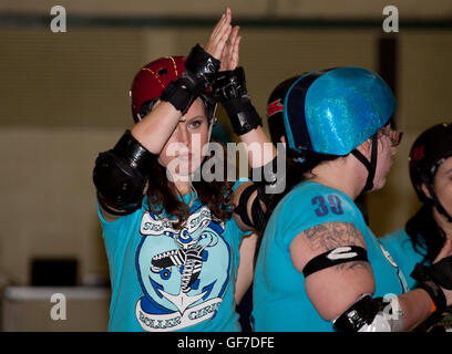Donna roller derby pattinatore esegue un punto o gesto/segnale Foto Stock
