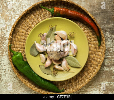 Composizione con spezie e verdure in cesto in vimini rustico tavolo da cucina Foto Stock