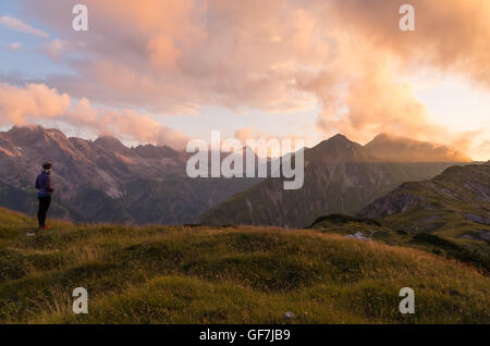 Femmina guardando il bellissimo tramonto in montagna vicino a Oberstdorf, Germania Foto Stock