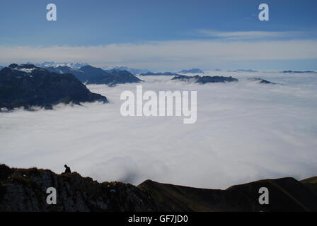 Escursionista sopra il mare di nebbia in Svizzera Foto Stock