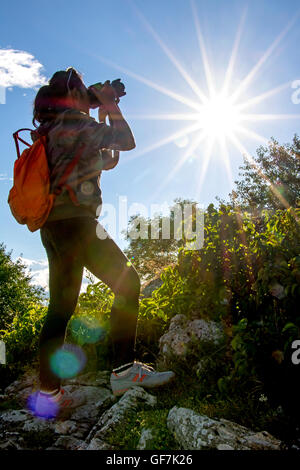 Silhouette di donna fotografo in natura sono back-luce dal sole Foto Stock