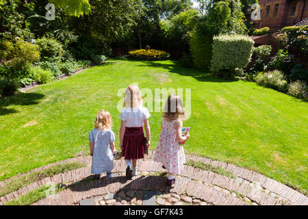 Greyfriars' House e giardini con 3 bambini / Kids / kid circa a correre e giocare in giardino prato erba. Frate St, Worcester. Regno Unito Foto Stock