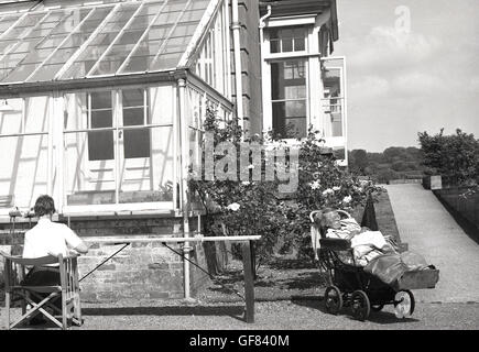 Degli anni Cinquanta, storico, signora anziana in casa di cura e di riposo in cattedra al di fuori, Inghilterra. Foto Stock