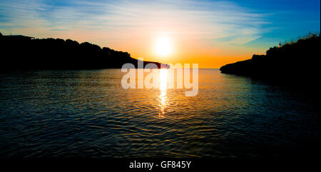 Scogliere al tramonto. Sunrise in mare Foto Stock