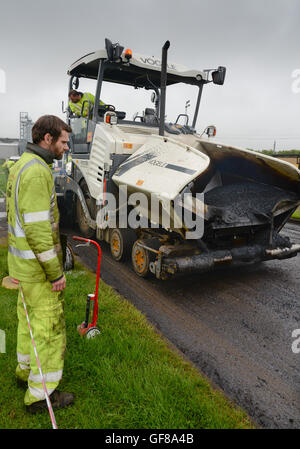 Una Vogele Super 1803-31 lastricatore, azionato dalla Northumberland County Council di effettuare road resurfacing Foto Stock