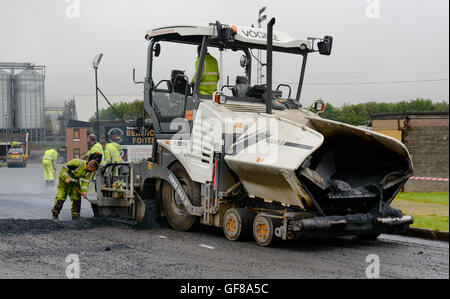 Una Vogele Super 1803-31 lastricatore, azionato dalla Northumberland County Council di effettuare road resurfacing Foto Stock