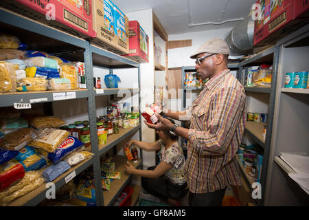 Volontari magazzino un foodbank con disposizioni. Foto Stock