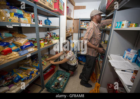 Volontari magazzino un foodbank con disposizioni. Foto Stock