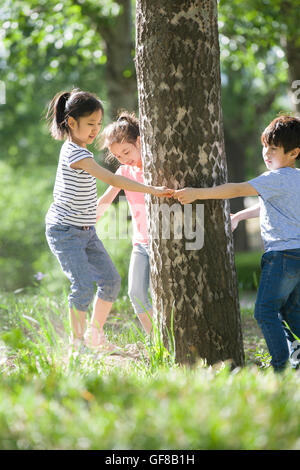 Felici i bambini cinesi a giocare nei boschi Foto Stock