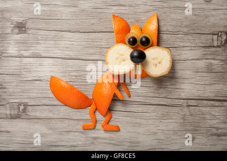 Lo scoiattolo realizzata di banana e arancione sul pannello di legno Foto Stock