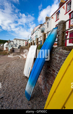Canoe e barche appoggiata contro la parete di costiera a Kingsand, Cornwall, Regno Unito Foto Stock