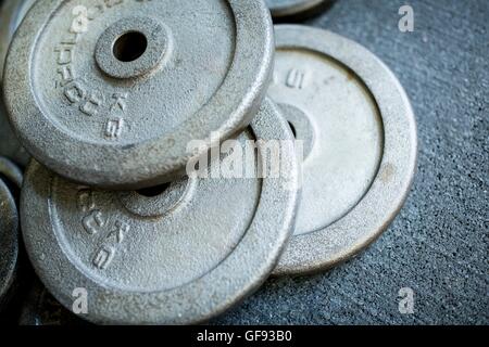 Proprietà rilasciato. Close-up di peso pesante Piastre mantenute da strack sul terreno. Foto Stock