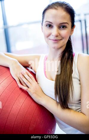 Proprietà rilasciato. Modello rilasciato. Ritratto di giovane donna con sfera di fitness in palestra. Foto Stock