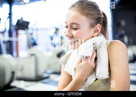 Proprietà rilasciato. Modello rilasciato. Giovane donna tergi il suo sudore con asciugamano dopo esercizio in palestra. Foto Stock