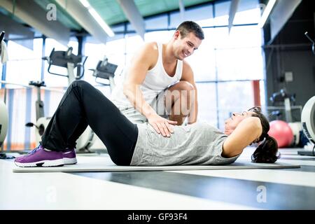 Proprietà rilasciato. Modello rilasciato. Giovane uomo formazione istruttori senior con donna in palestra. Foto Stock