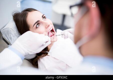 Modello rilasciato. Dentista esaminando denti del paziente in Clinica del dentista. Foto Stock