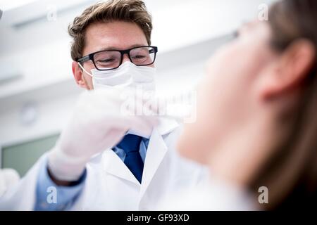 Modello rilasciato. Dentista esaminando denti del paziente in Clinica del dentista. Foto Stock