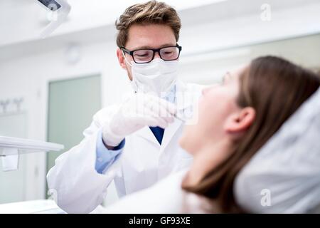 Modello rilasciato. Dentista esaminando denti del paziente in Clinica del dentista. Foto Stock