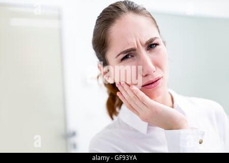 Modello rilasciato. Giovane donna che soffre di mal di denti, studio shot. Foto Stock