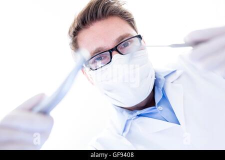 Modello rilasciato. Dentista holding trapano dentistico. Foto Stock