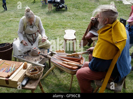 Coppia di anziani mostra primi medievale di perle di vetro la produzione di aiuto del piccolo portatile forno di argilla, Kungsbacka, Svezia Foto Stock