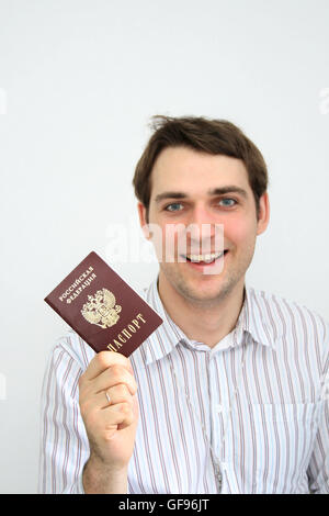 Uomo felice con un passaporto russo in mano Foto Stock