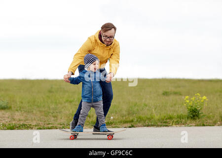 Felice padre e figlio su skateboard Foto Stock