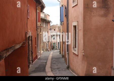 Tapparelle su ocra edifici colorati per le strade di Roussillon, Provenza, Francia Foto Stock