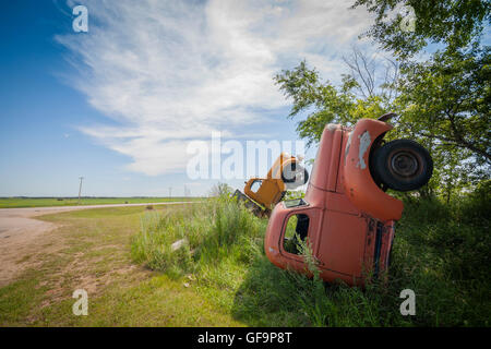 Due camion sepolti verticali degli anni '40 presso la strada a Saskatchewan Canada Foto Stock