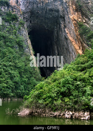 Passando alla bocca della grotta di Rondine nel torrente Shennong, un affluente del fiume Yangtze in Cina. Foto Stock