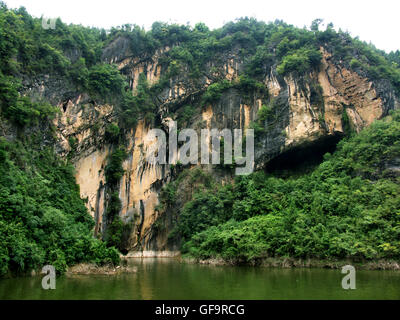 Passando alla bocca della grotta di Rondine nel torrente Shennong, un affluente del fiume Yangtze in Cina. Foto Stock