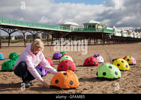 Lytham St Anne, vicino a Blackpool, Regno Unito. Il 30 luglio, 2016. St Anne's Kite Festival; Lynn Bleasdale, su del primo kiters di arrivare, imposta la sua 60 homeade coccinella bug terreno buttafuori, rimbalzando Ladybug, Coccinella manica a vento, gommoni sulla spiaggia in venti leggeri, su una soleggiata giornata di luglio. Foto Stock