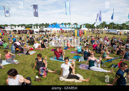 Charlton Park, Regno Unito. Il 30 luglio, 2016. Centinaia di persone prendono parte a un gruppo di mattina sessione di yoga in una soleggiata Womad Festival, 30 luglio 2016. Credito: Adam Gasson/Alamy Live News Foto Stock